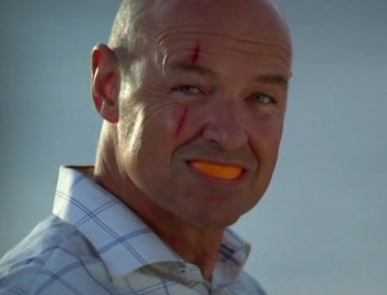 Scary-looking Locke freaking out his fellow LOST-ies with an orange in his mouth